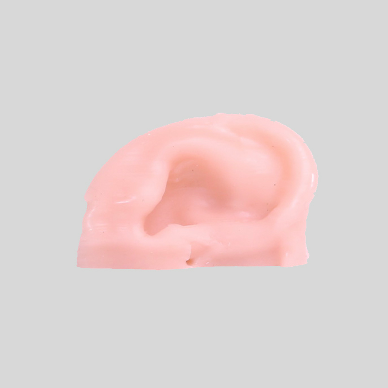 A close-up of a realistic, pink ear prosthetic made of silicone against a plain, light gray background, showcasing its smooth texture and intricate details—a true game-changer in silicone 3D printing.